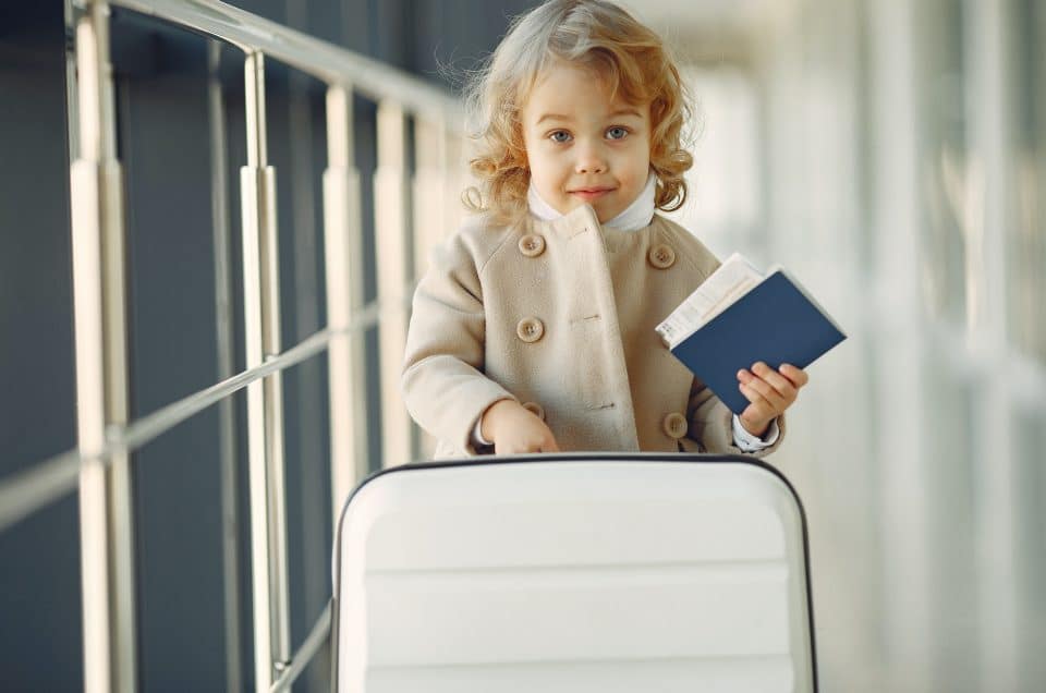 Blonde boy pulls luggage